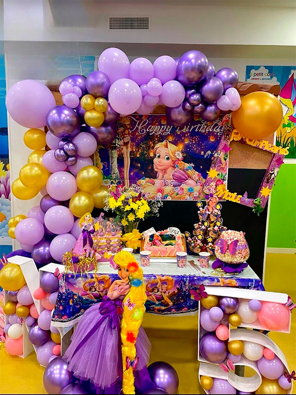 Fotografía de una decoración de cumpleaños para una niña en la Ludoteca de Le Petit Cocó, con motivos de princesas y globos morados