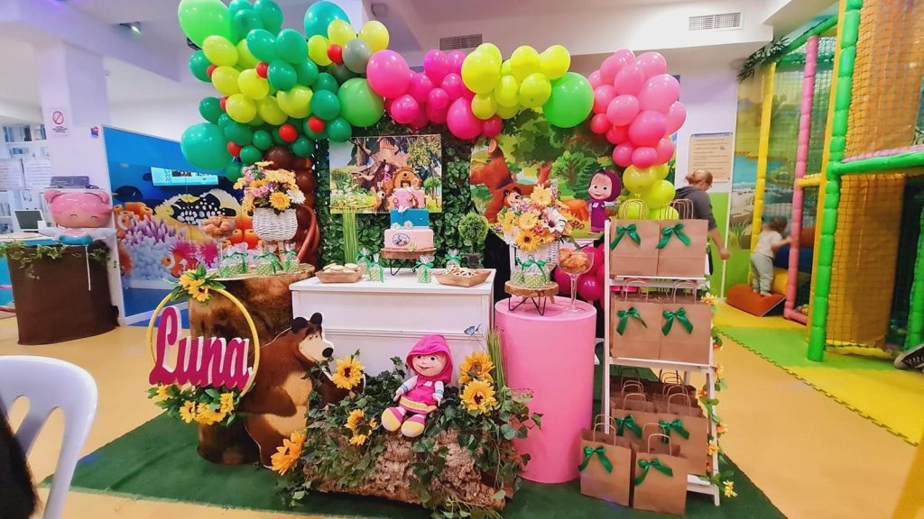 Fotografía de las instalaciones de Le Petit Cocó Fuengirola: mesa de regalos con motivos de "Masha y el Oso" y globos